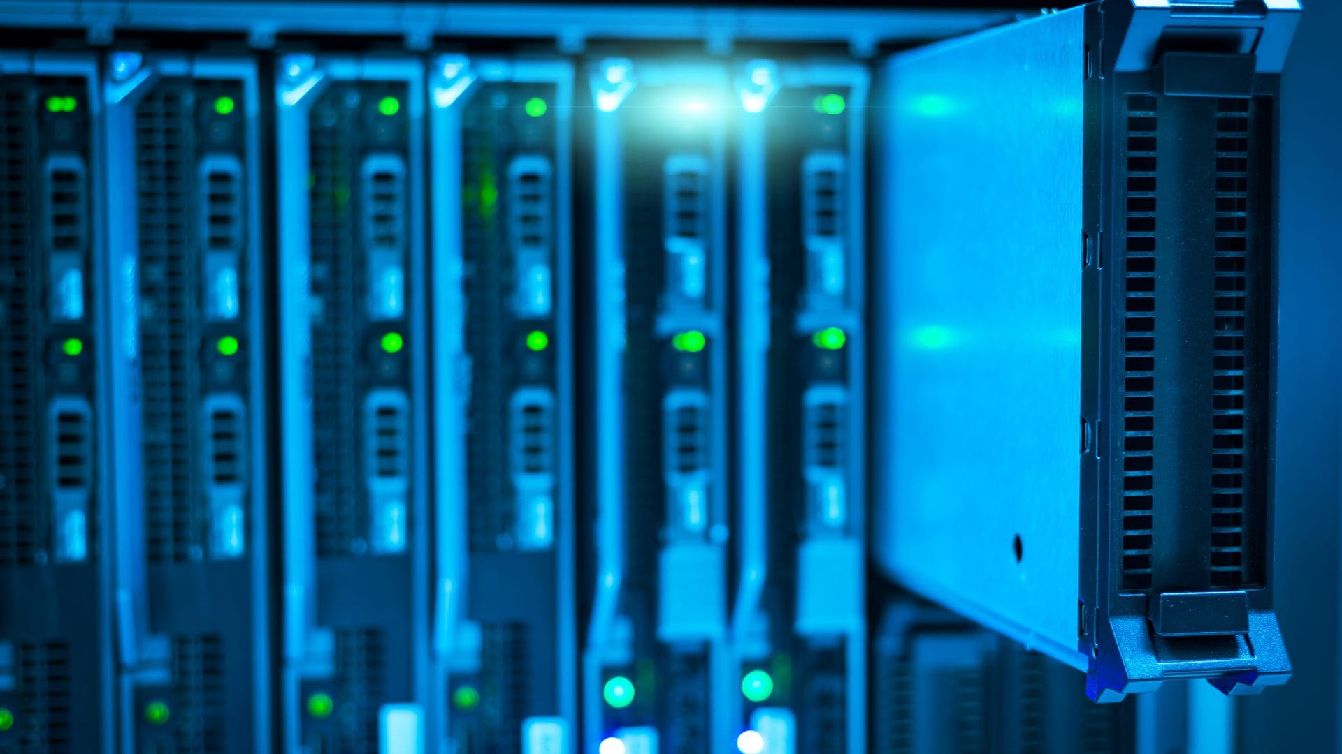 Rack-mounted server and storage units with rows of drive bays and green status lights in a server room