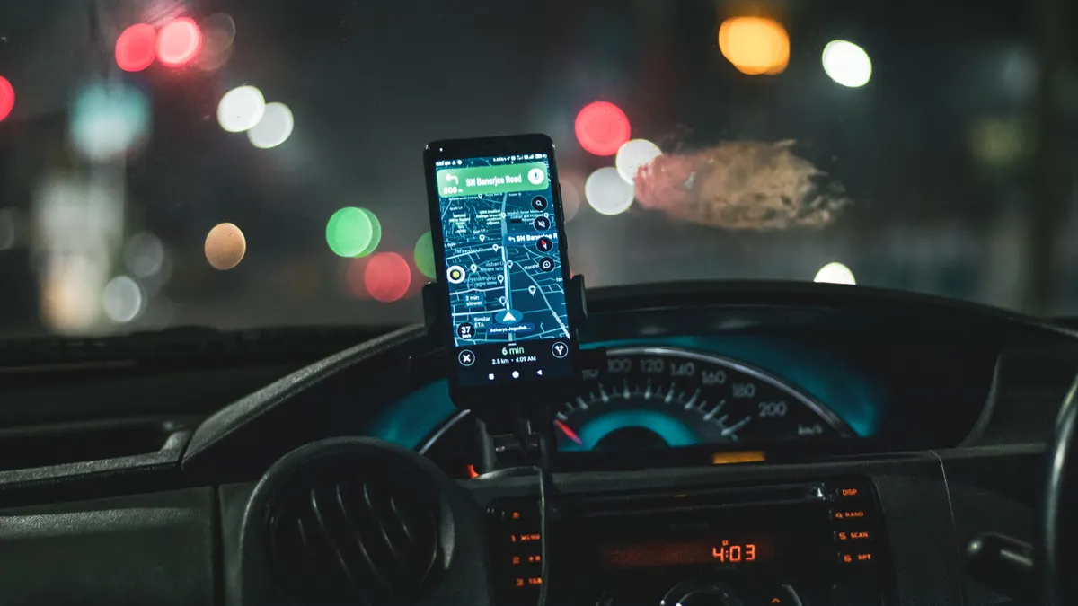 Driver device management: a smartphone in a dashboard mount inside a vehicle cab at night