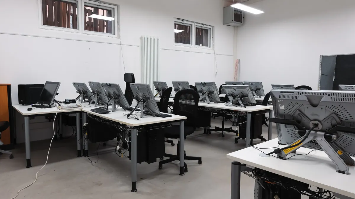Empty school computer lab with rows of classroom devices ready for lessons