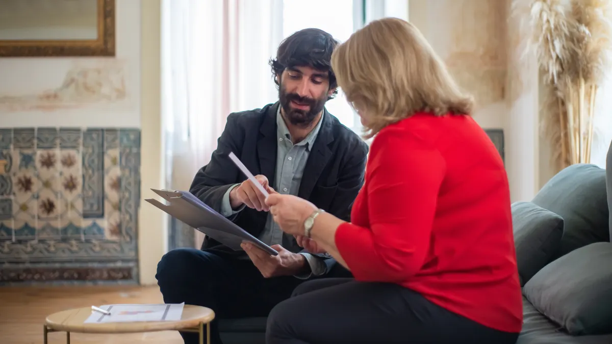Financial adviser reviewing client ID documents in a folder with a client