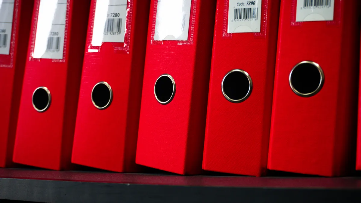 Law firm backup and recovery: a row of red file binders on an office shelf